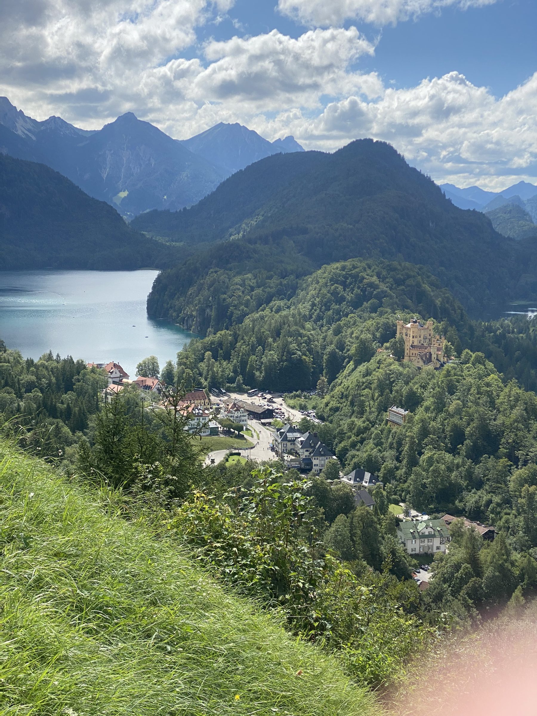 Hohenschwangau Castle above a valley lake and alpine village